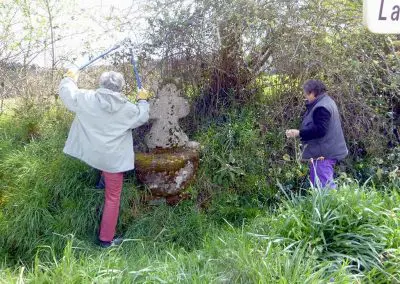 Photo d'une croix de Crozant en train d'être entretenue par des membres de l'association ASCTC pendant une action de débroussaillage.
