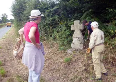 Photo d'une croix de Crozant en train d'être entretenue par des membres de l'association ASCTC pendant une action de débroussaillage.
