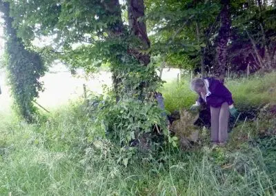 Photo d'une croix de Crozant en train d'être entretenue par des membres de l'association ASCTC pendant une action de débroussaillage.