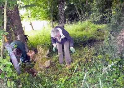 Photo d'une croix de Crozant en train d'être entretenue par des membres de l'association ASCTC pendant une action de débroussaillage.