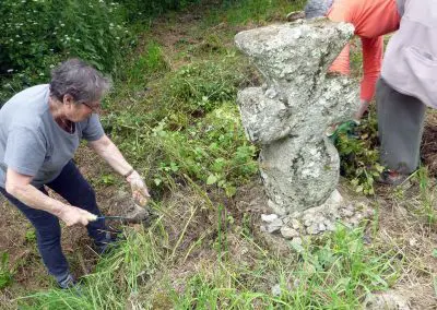 Photo d'une croix de Crozant en train d'être entretenue par des membres de l'association ASCTC pendant une action de débroussaillage.